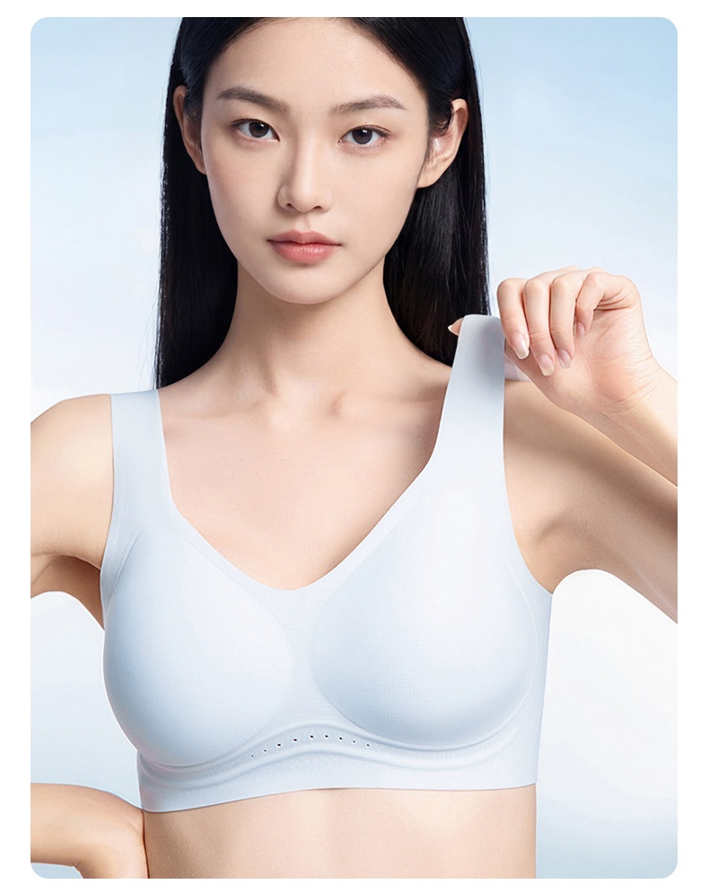 Model wearing light blue seamless bra while holding wide shoulder strap VEIMIA