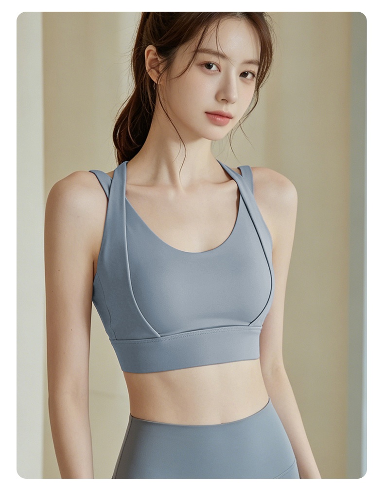 Model wearing blue cross back high impact sports bra front view VEIMIA
