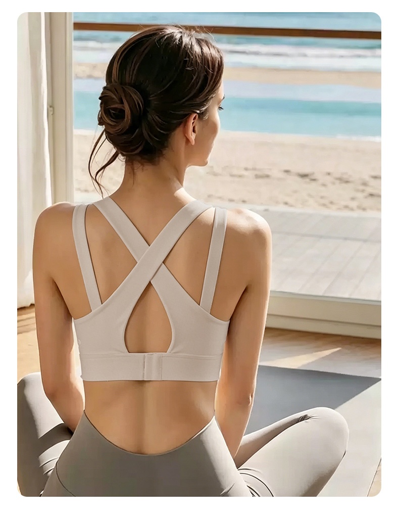 Model wearing gray sports bra back view showing cross back straps and adjustable closure VEIMIA