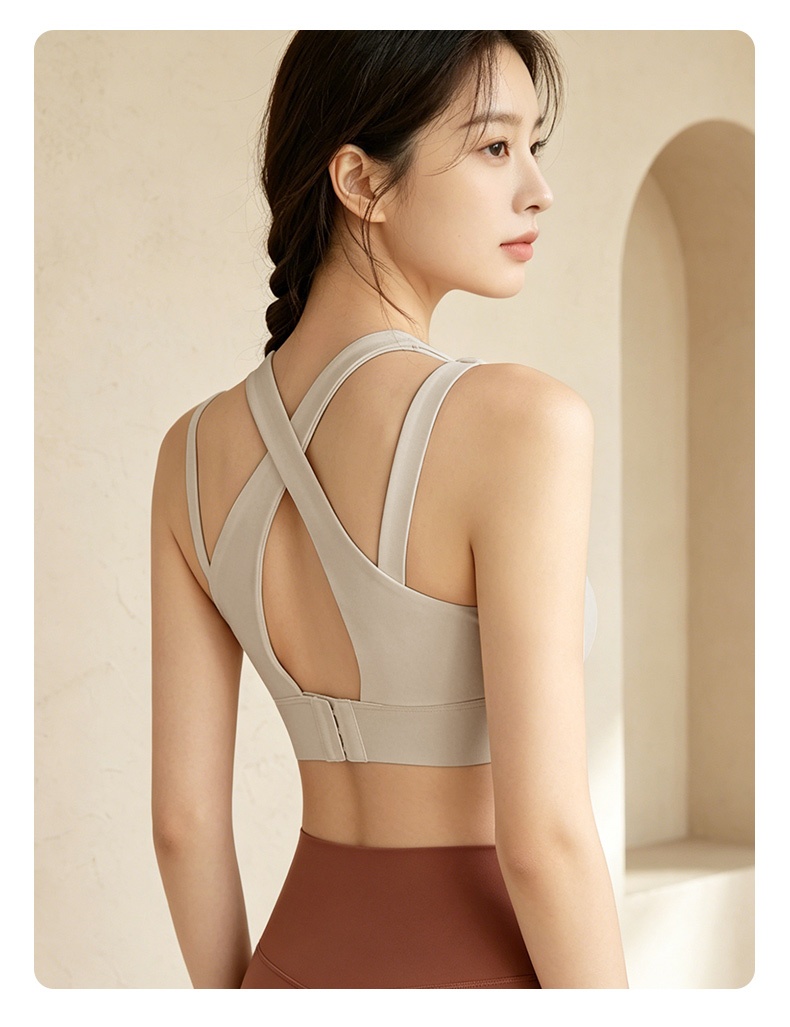 Model wearing gray sports bra back view showing cross back straps and adjustable closure VEIMIA