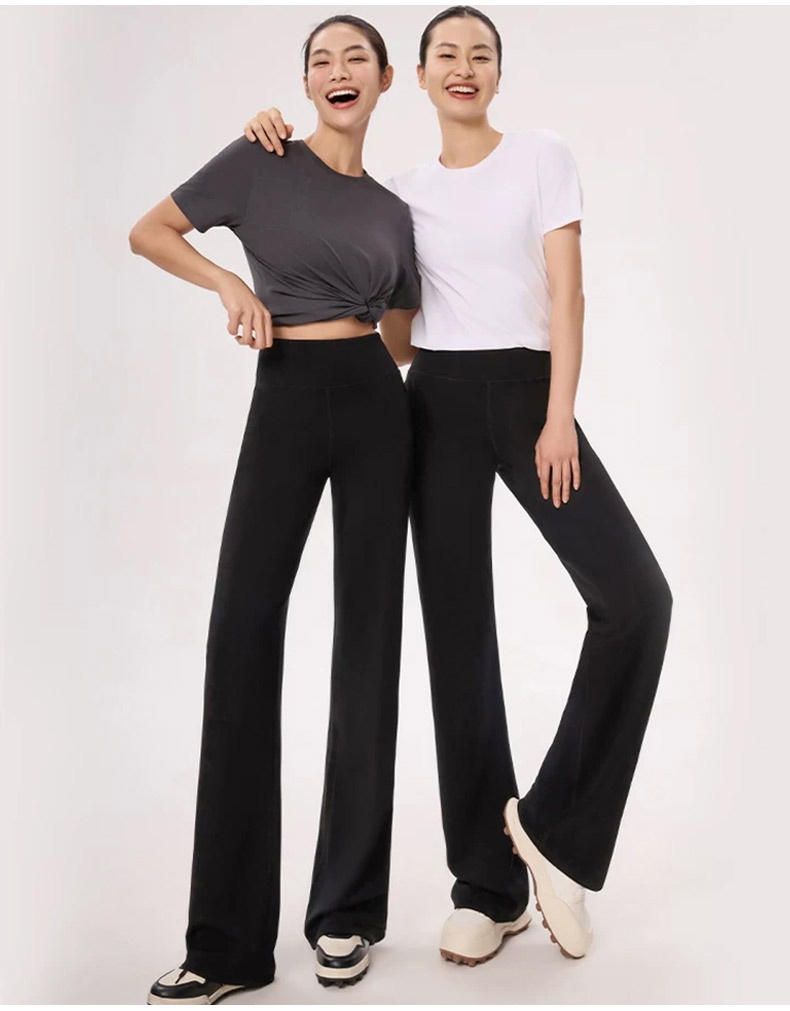 Two models wearing black straight-cut pants in front studio pose VEIMIA
