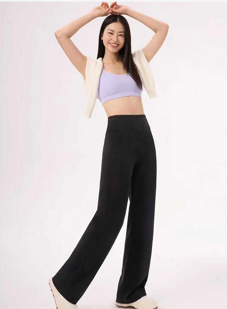 Model wearing black straight-cut pants with casual sporty styling VEIMIA