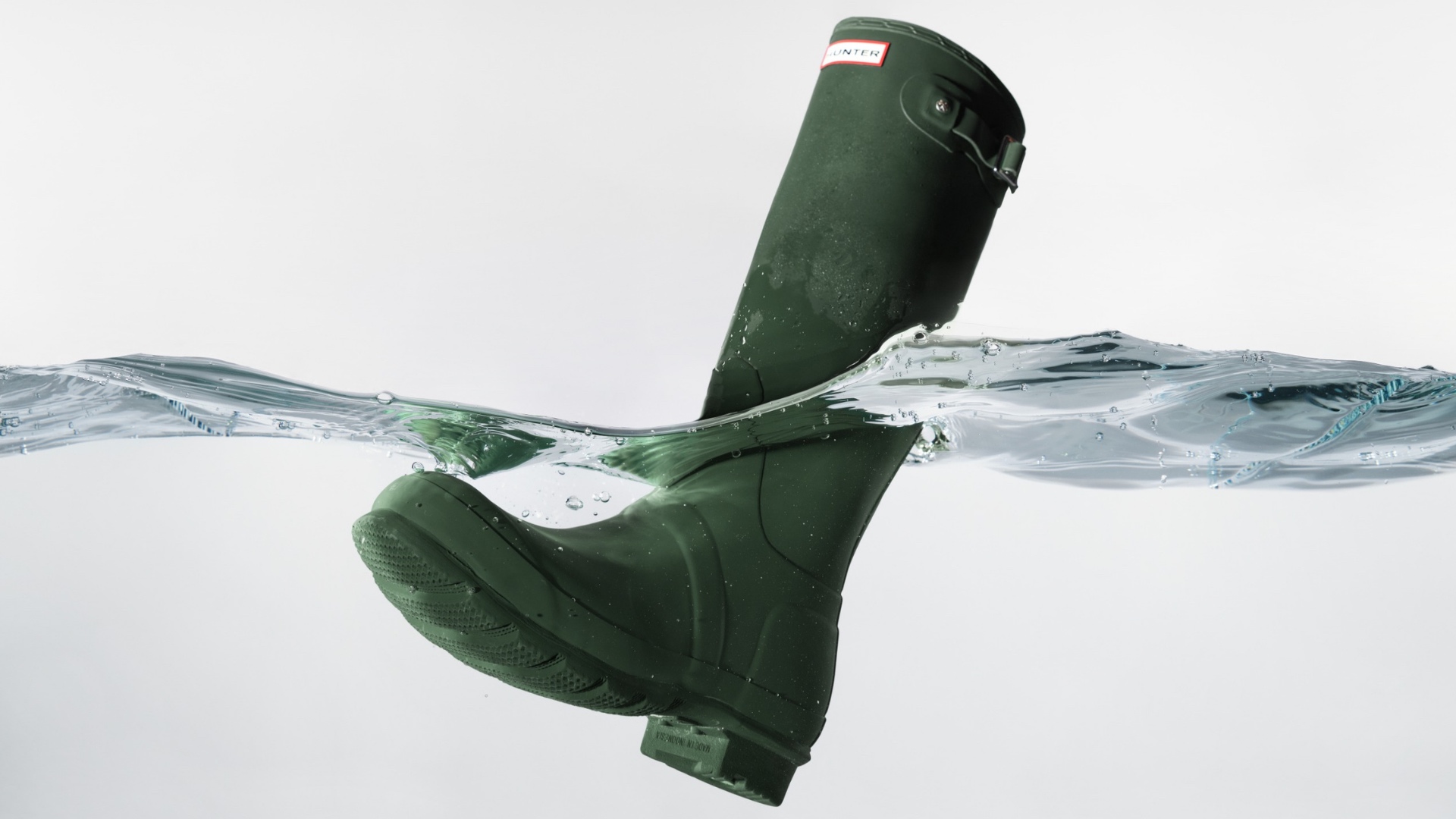 Modern lifestyle photo of Hunter premium boots in Singapore worn with a light striped outfit.