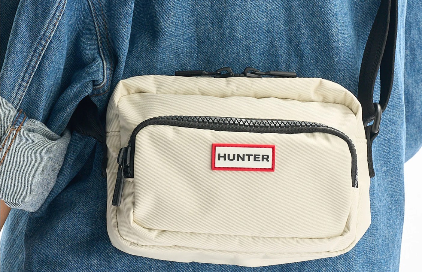 Close-up of a cream Hunter crossbody bag with zip pocket and logo, a stylish example of nylon bags in Singapore for daily commutes.