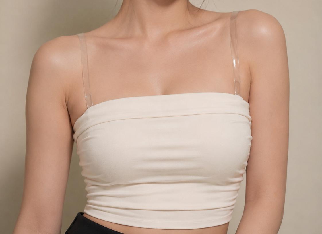 투명 어깨끈과 함께 착용한 베이지 스트랩리스 브라 클로즈업 이미지