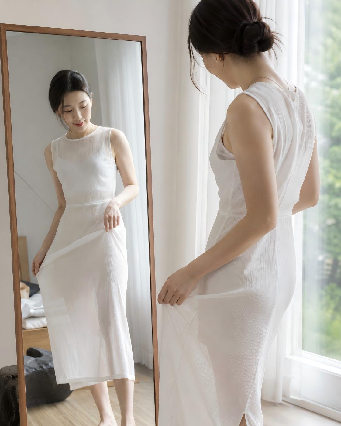 거울 앞 자연광에서 흰 원피스의 비침 정도를 확인하는 여성