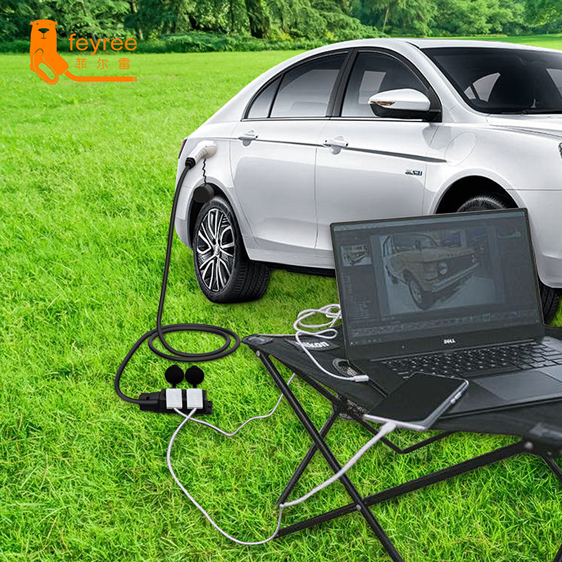 Portable V2L EV charging adapter cable powering a laptop and phone outdoors for convenient remote work.