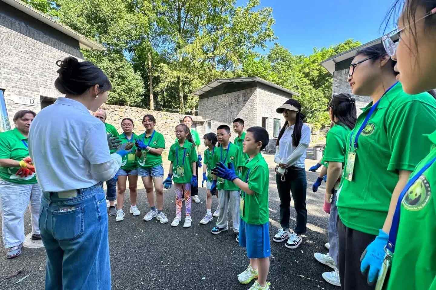 大熊猫保護基地で作業服を着たボランティア参加者