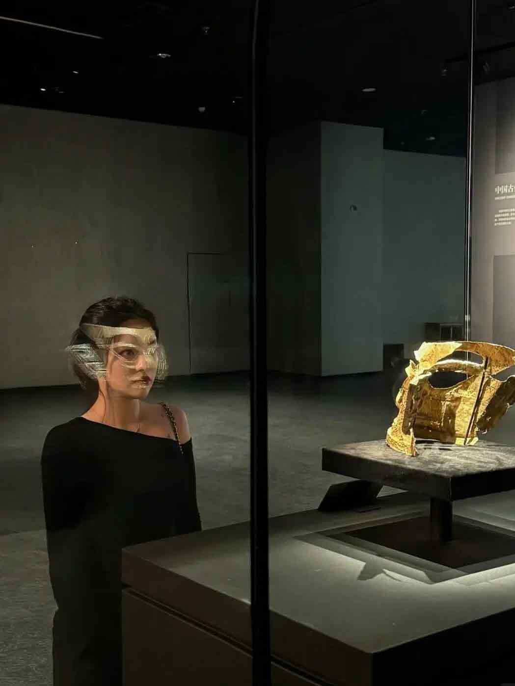 三星堆博物館の黄金仮面と重なるように写真を撮る観光客