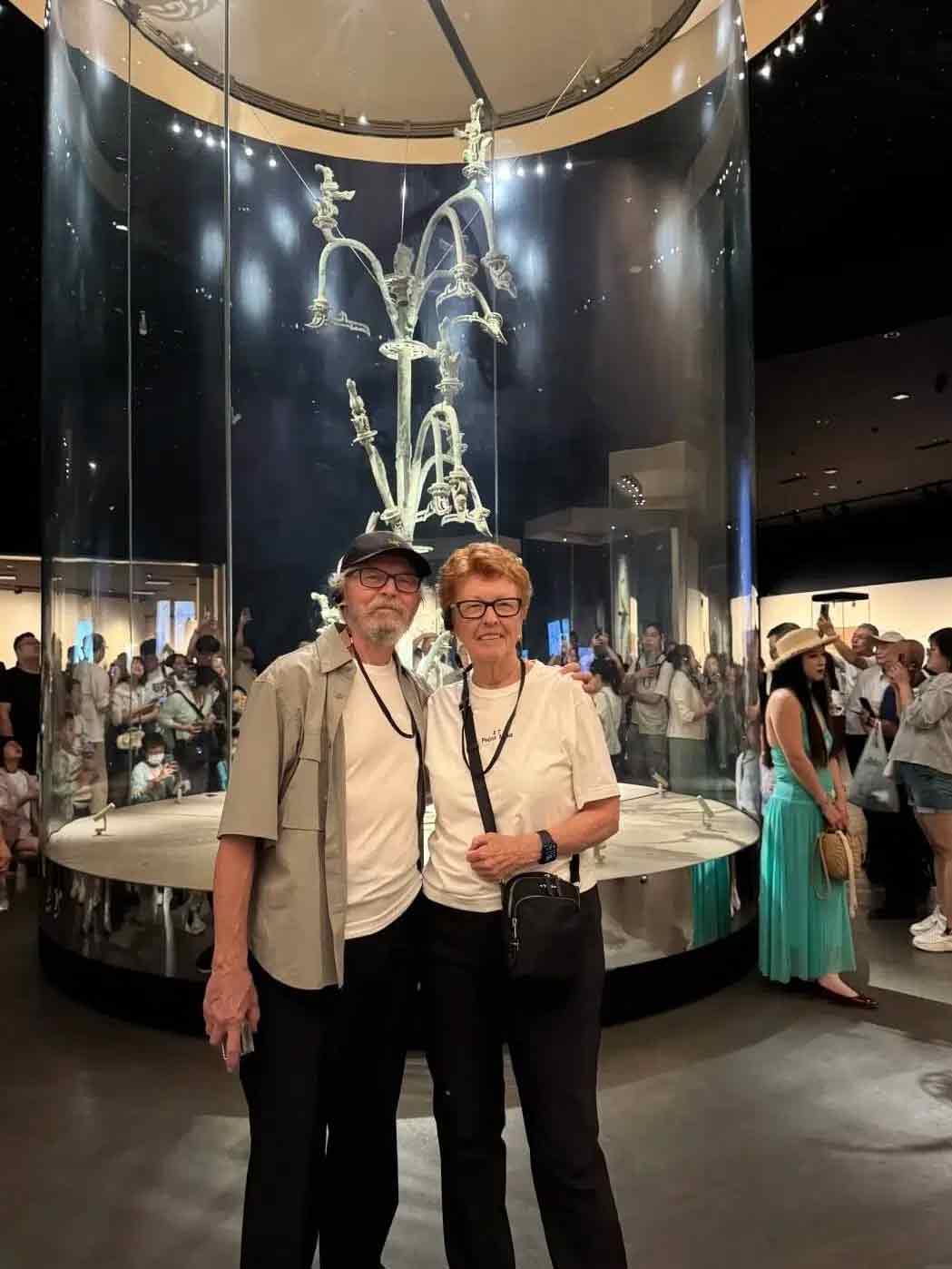 三星堆博物館の青銅神樹の前で記念撮影する観光客