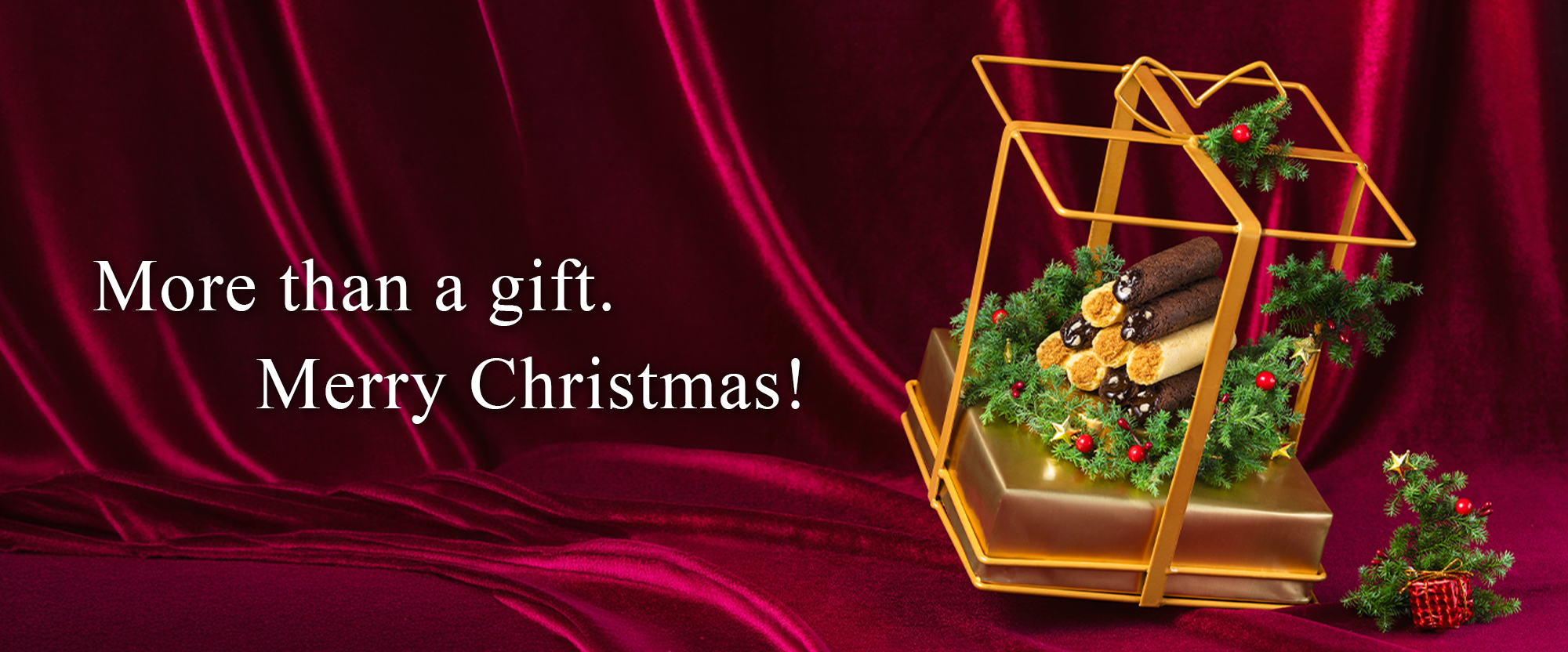 Festive Christmas gift display featuring filled egg rolls in a holiday wreath setting.