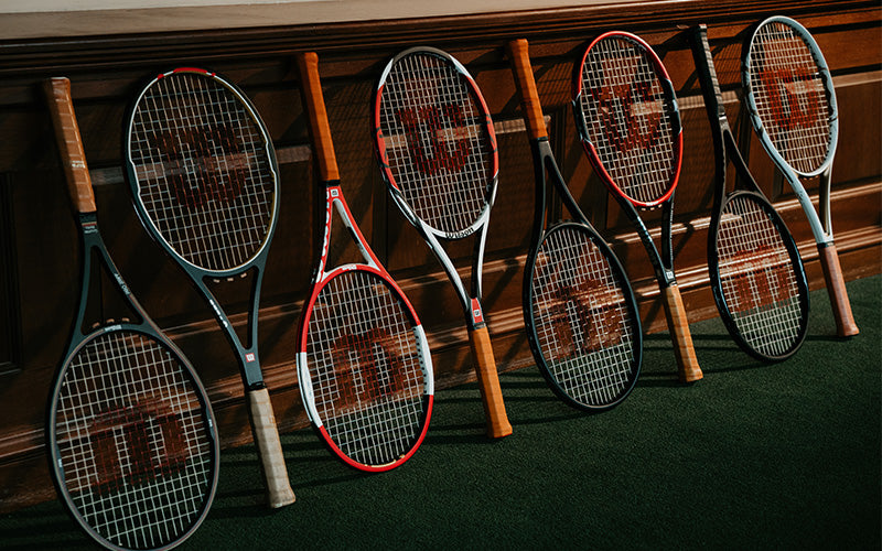 Wilson tennis rackets lined up against a wall