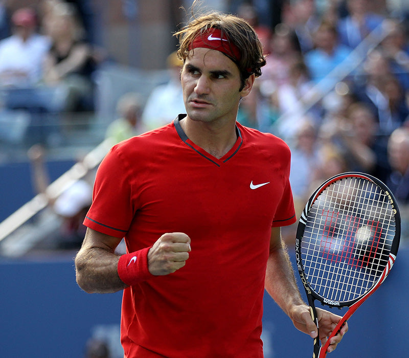 Roger Federer, holding his racket, celebrating