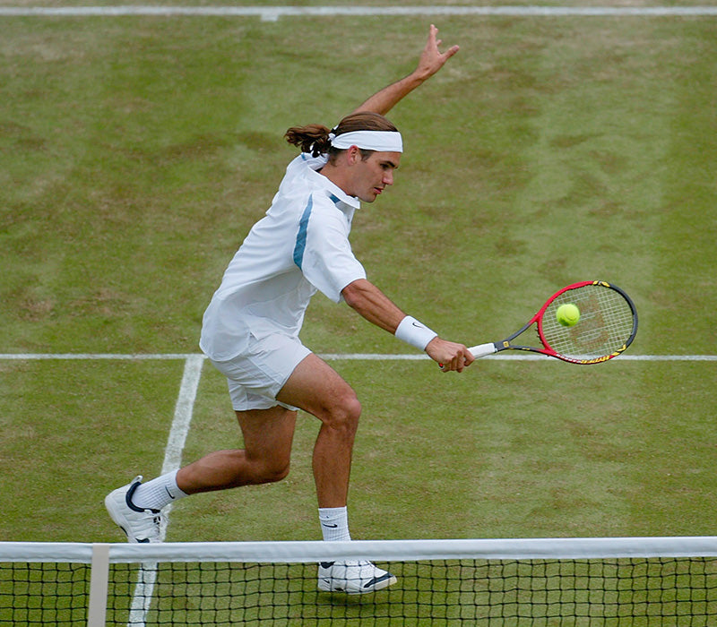 Roger Federer, earlier in his career, mid game about to hit a ball