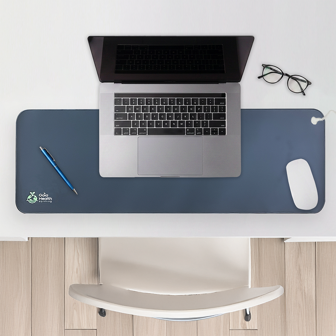 Gaia grounding mat on a desk beneath a laptop