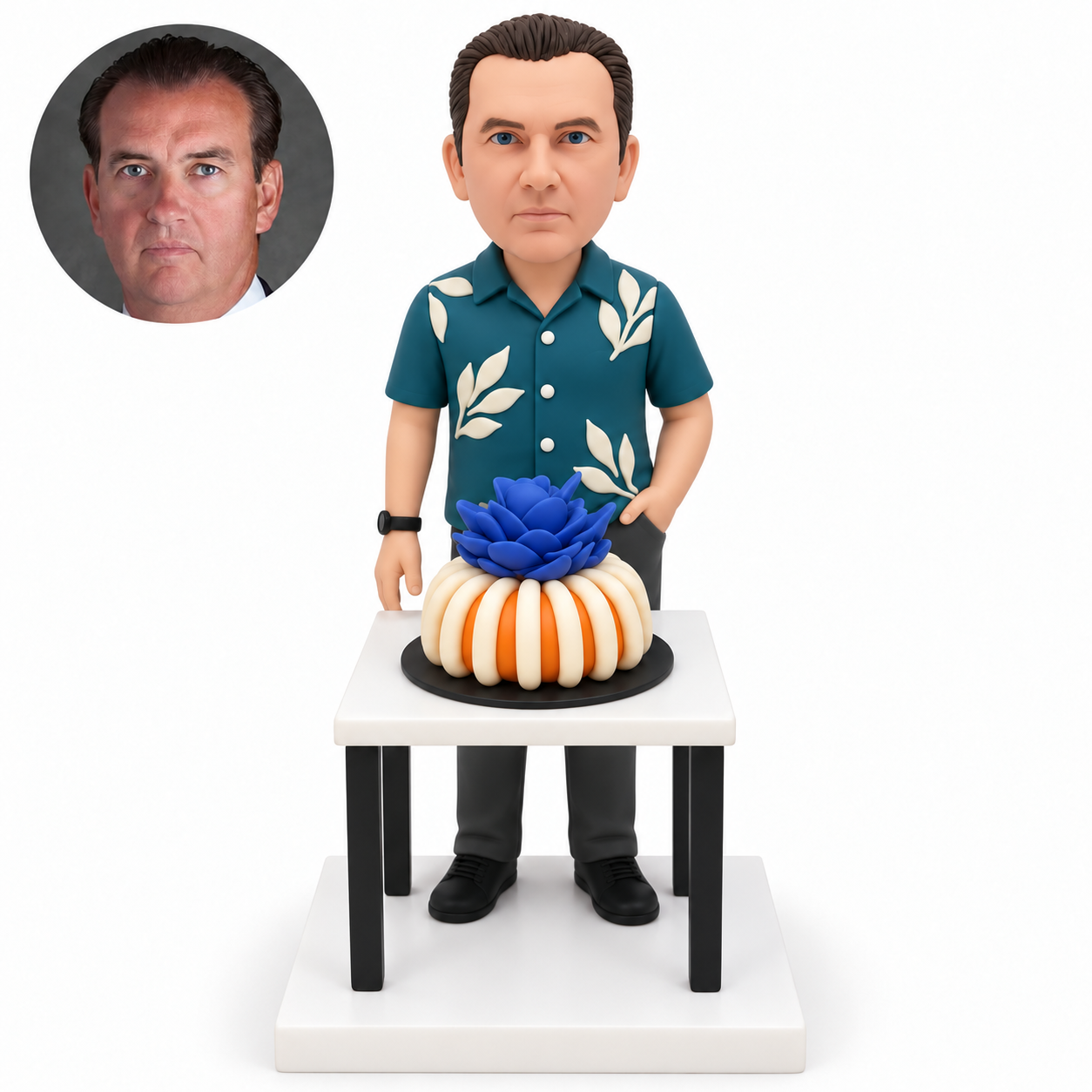 custom bobblehead figure man standing behind a table with a large flower-topped cake and his left hand in his pocket