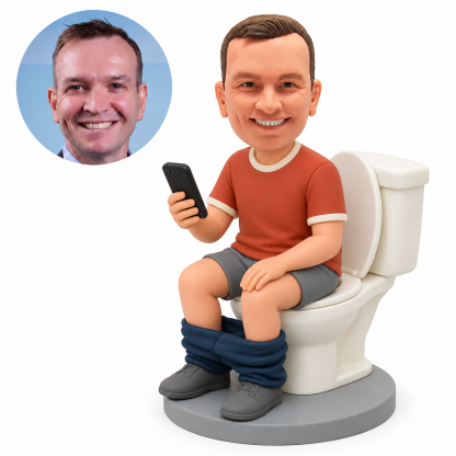 Custom polymer clay bobblehead man seated on a white toilet, raising a black phone in his right hand with his left palm resting on his thigh, with matching circular real portrait.