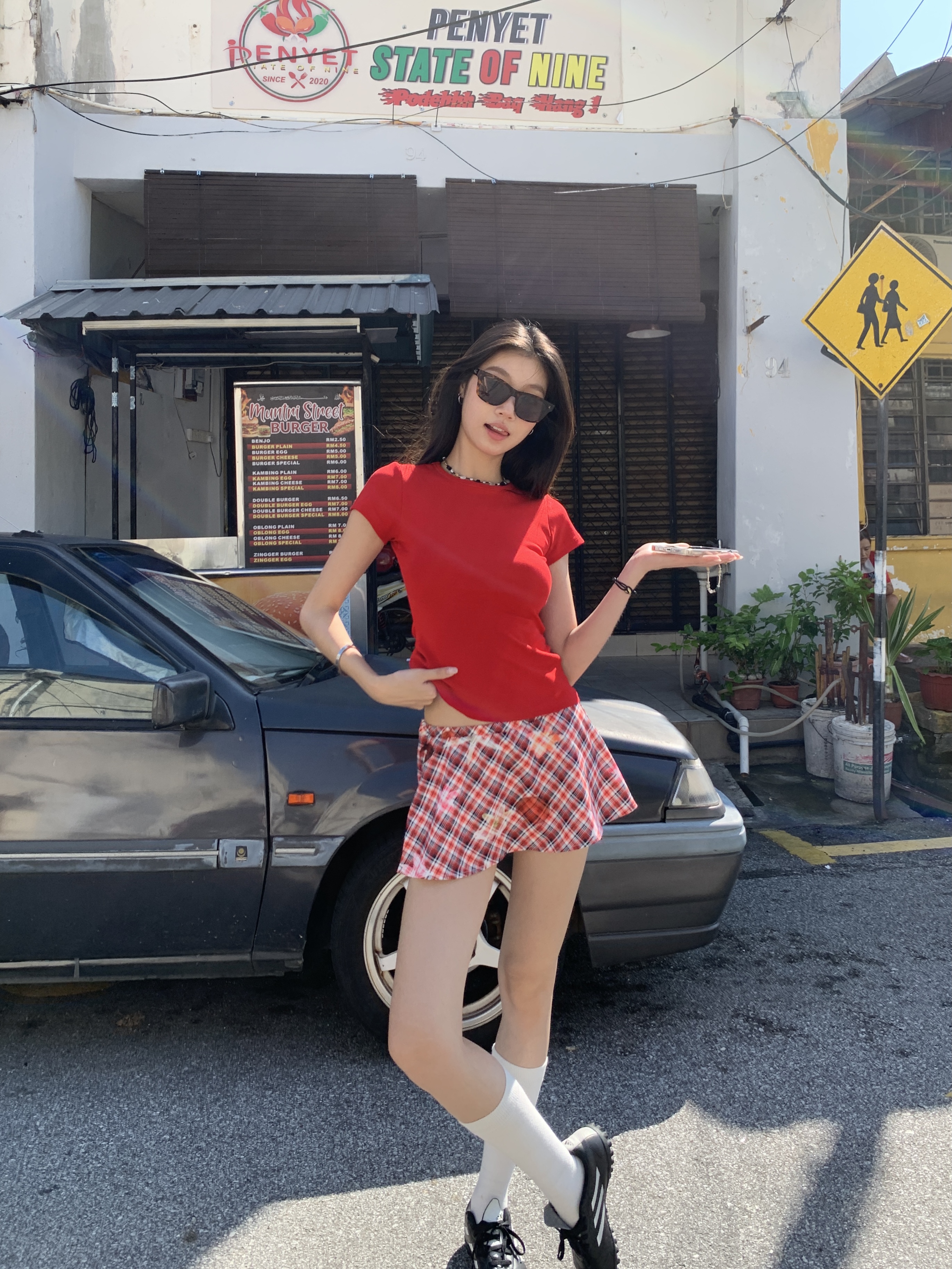 A short red plaid ruffle skirt with a high-low design, featuring a shorter front and longer back, styled for a sexy summer look.