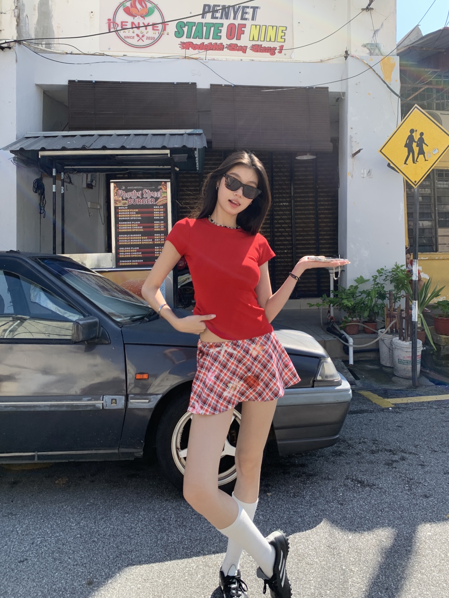 A short red plaid ruffle skirt with a high-low design, featuring a shorter front and longer back, styled for a sexy summer look.