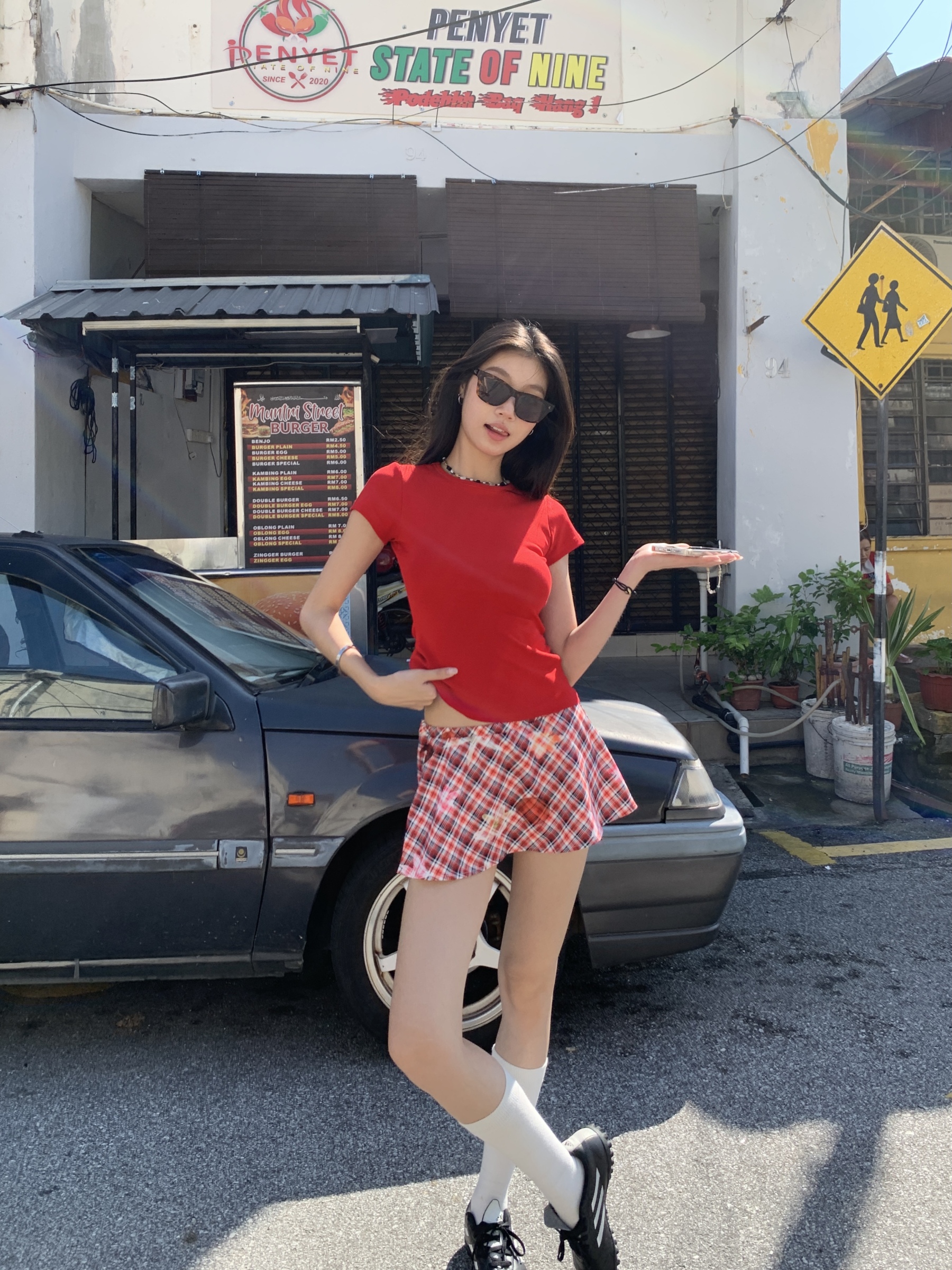 A short red plaid ruffle skirt with a high-low design, featuring a shorter front and longer back, styled for a sexy summer look.