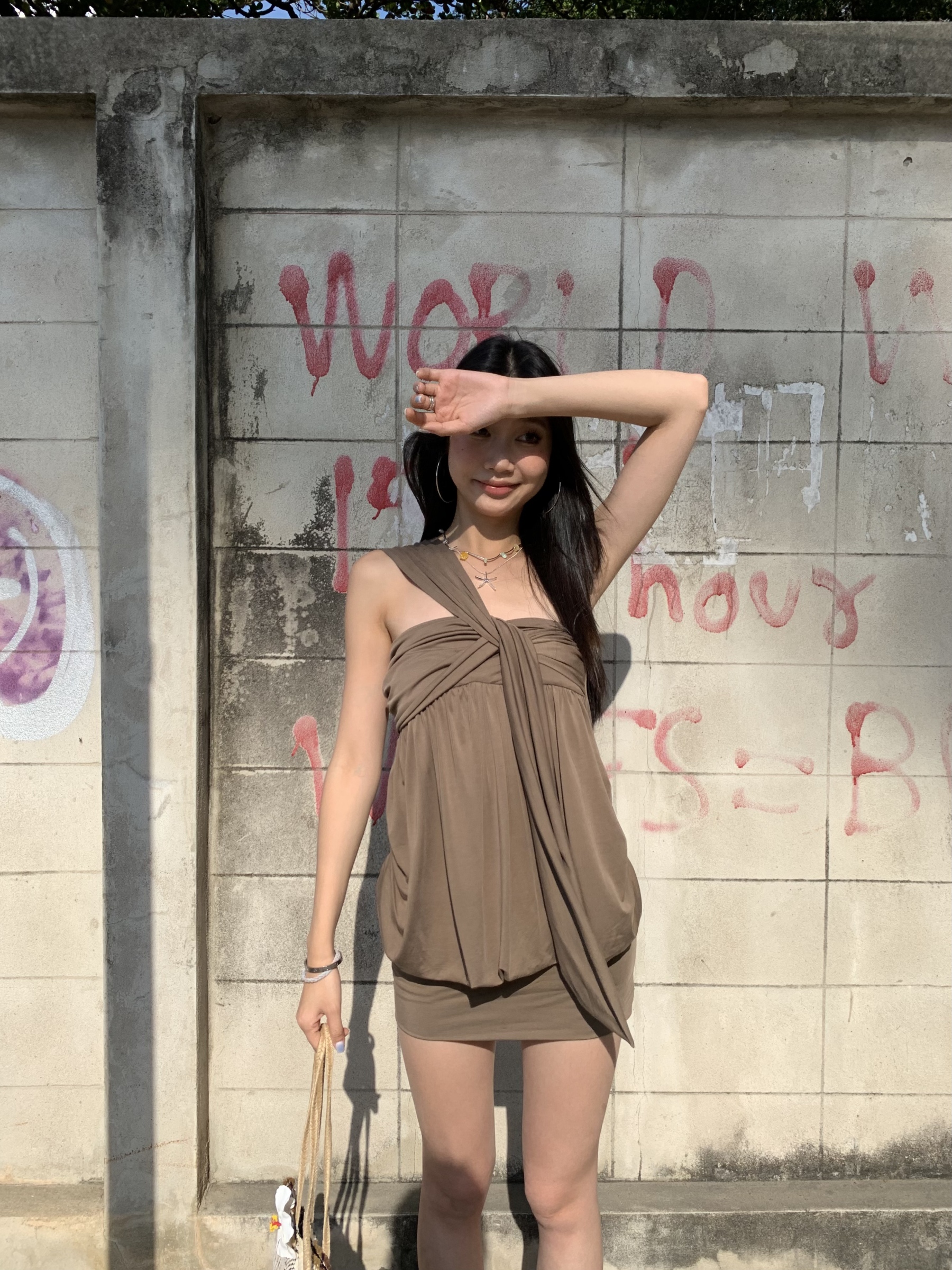 A casual dress with a single strap on one side, a twisted design at the chest, slimming the figure, a chic look designed for summer