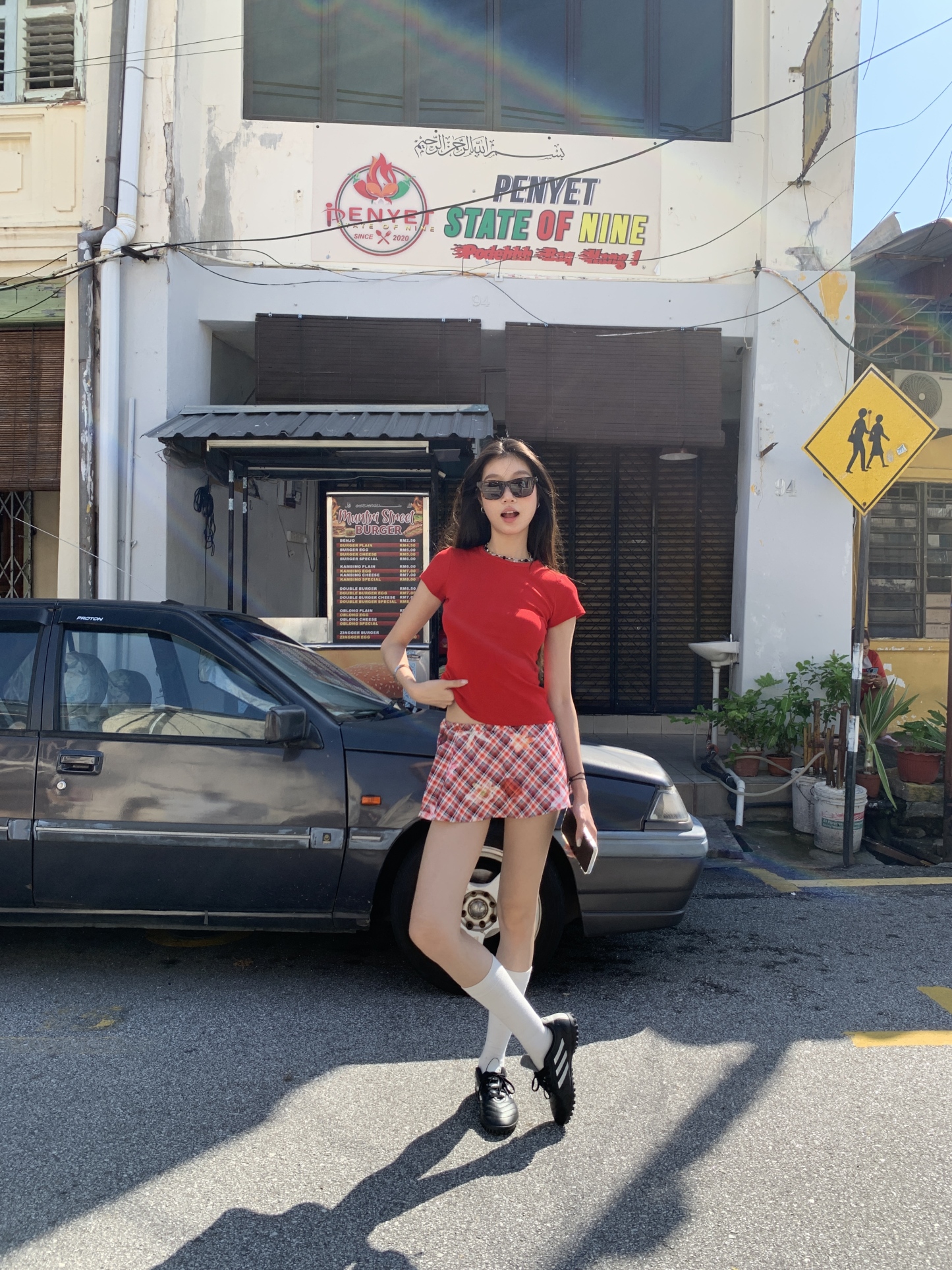 A short red plaid ruffle skirt with a high-low design, featuring a shorter front and longer back, styled for a sexy summer look.