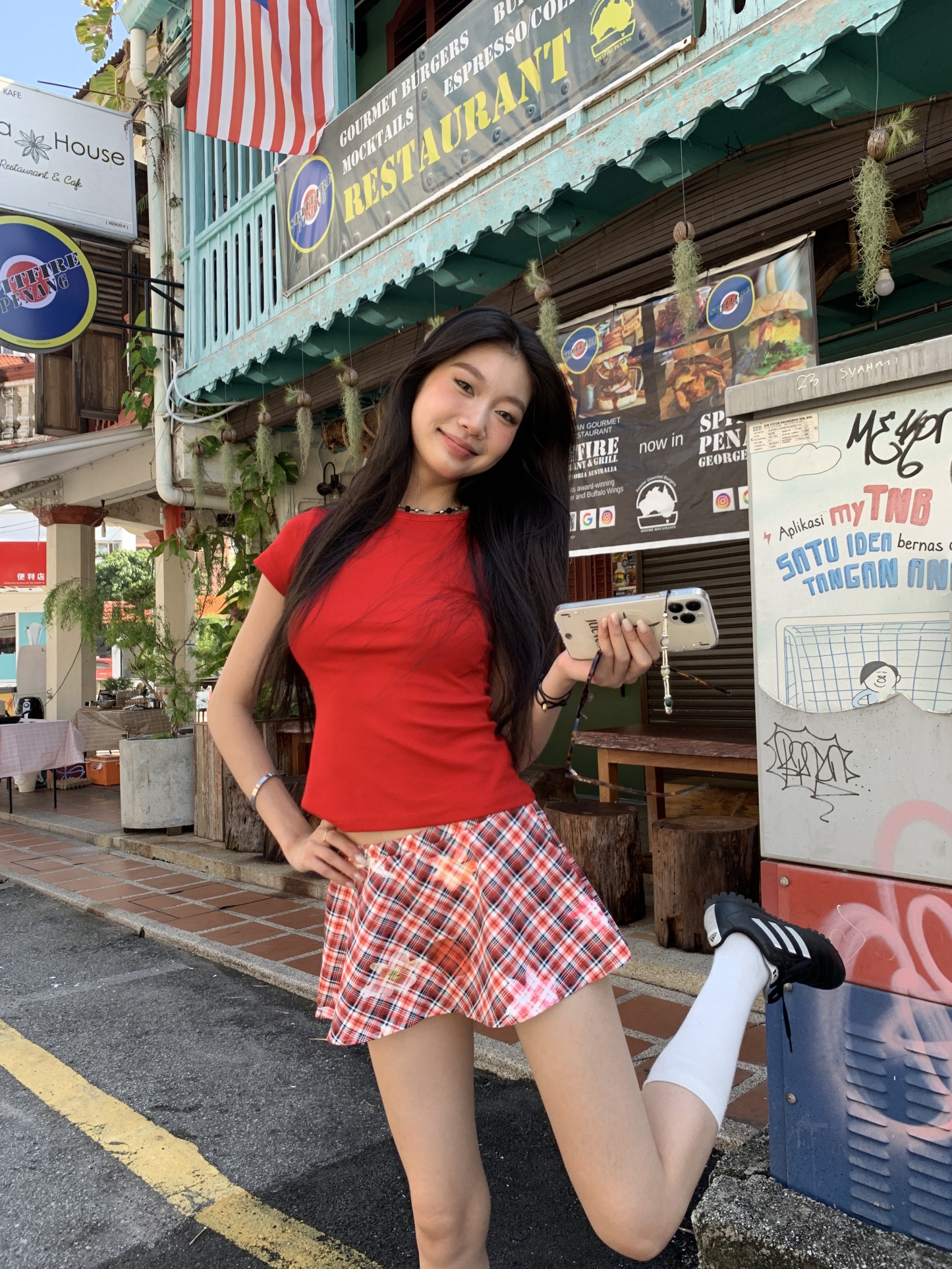 A short red plaid ruffle skirt with a high-low design, featuring a shorter front and longer back, styled for a sexy summer look.