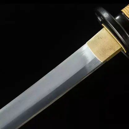 Detailed macro shot of the 1060 high carbon steel blade showing the authentic metal grain and brass habaki.