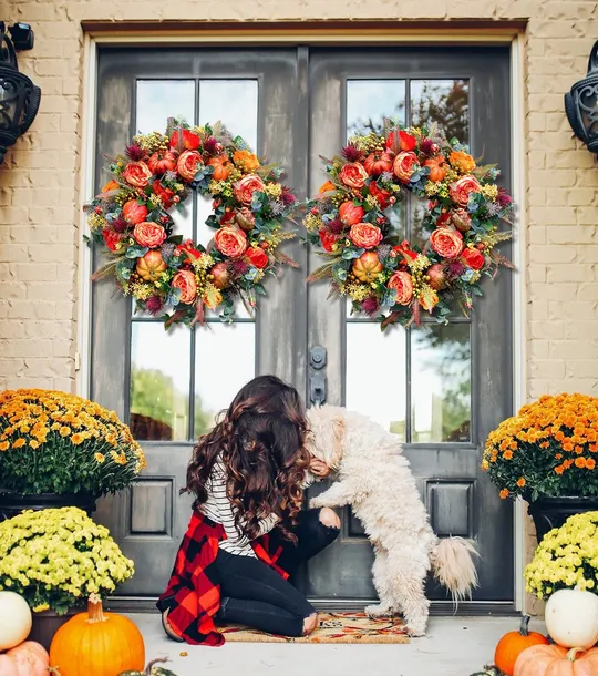 Handcrafted autumn wreath details with pumpkins peonies greenery and berries