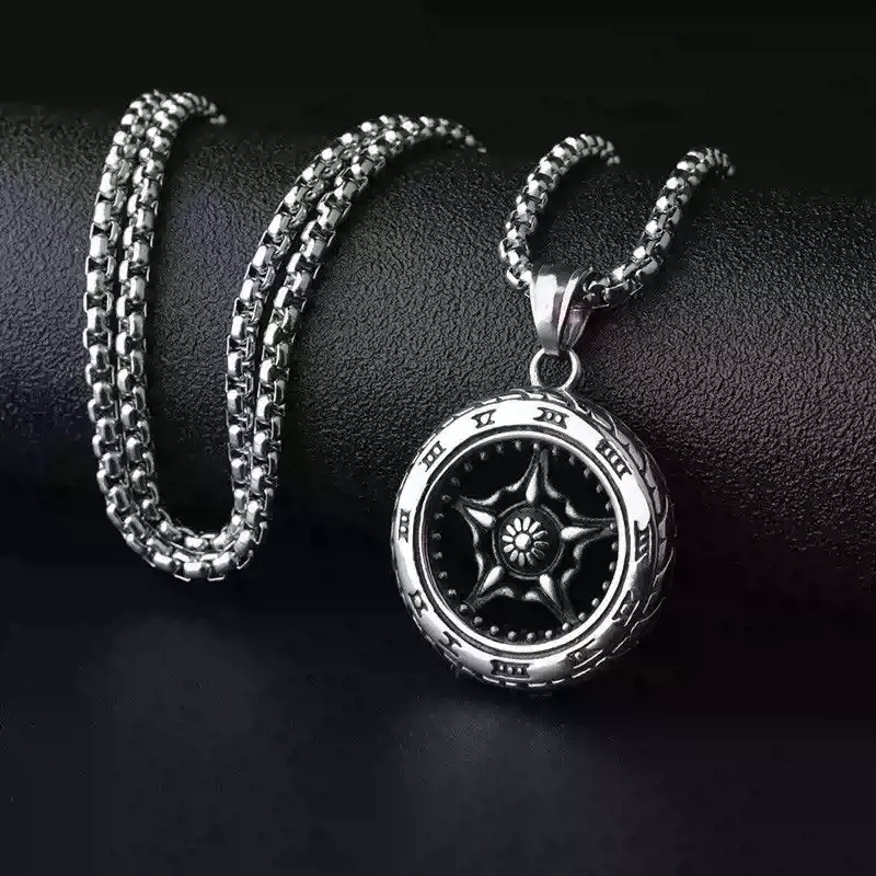 Detailed view of a silver biker wheel necklace showcasing engraved Roman numerals on the tire edge.