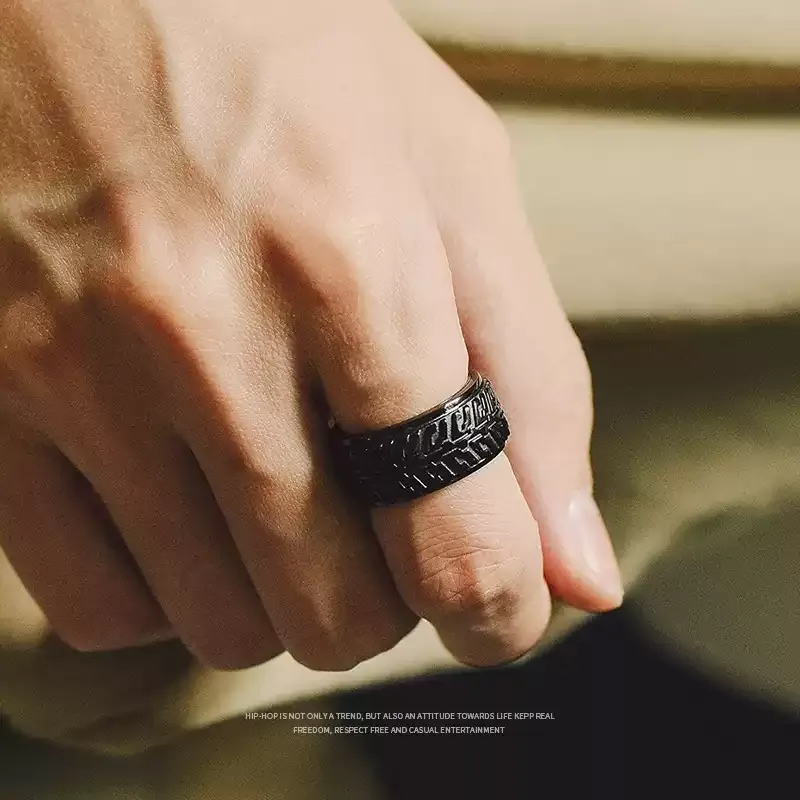 Close-up of a man's hand showcasing the black tire tread motorcycle ring.