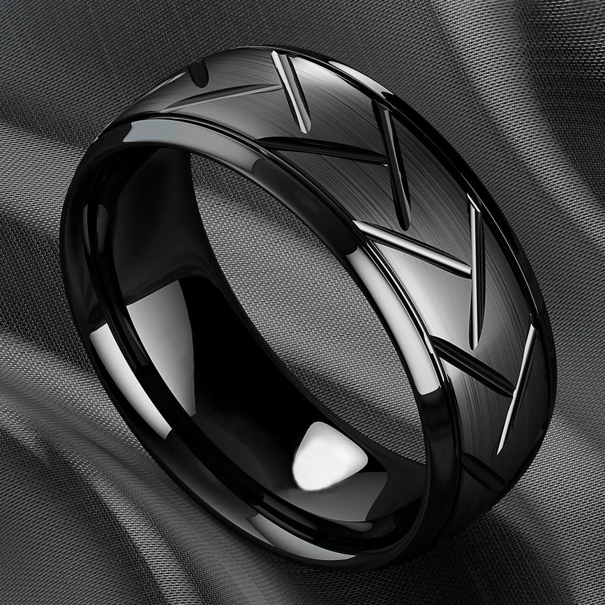 A black tungsten motorcycle tire tread ring featuring a brushed finish and polished grooved accents, displayed on a dark fabric background.