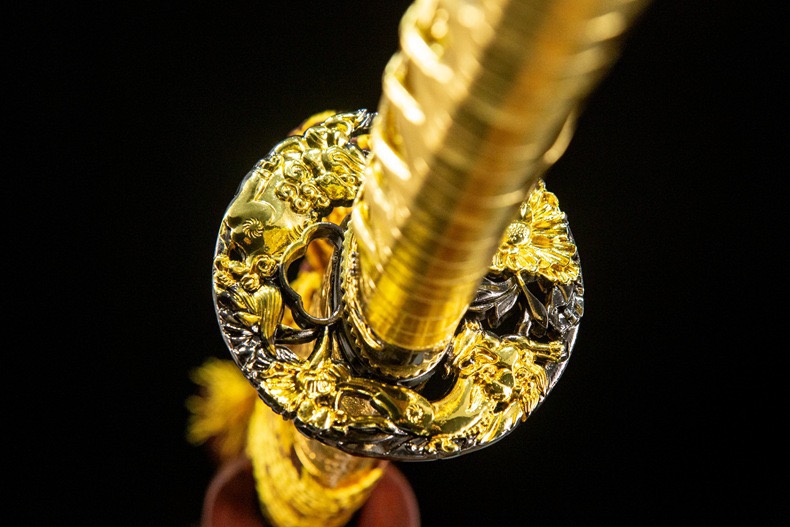 A horizontal view of the Gold Katana on a stand, placed over a traditional Japanese-style decorative mat.