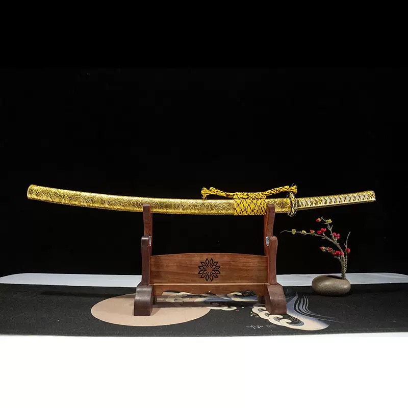 A full length gold katana with matching scabbard, resting on a decorative wooden sword stand.