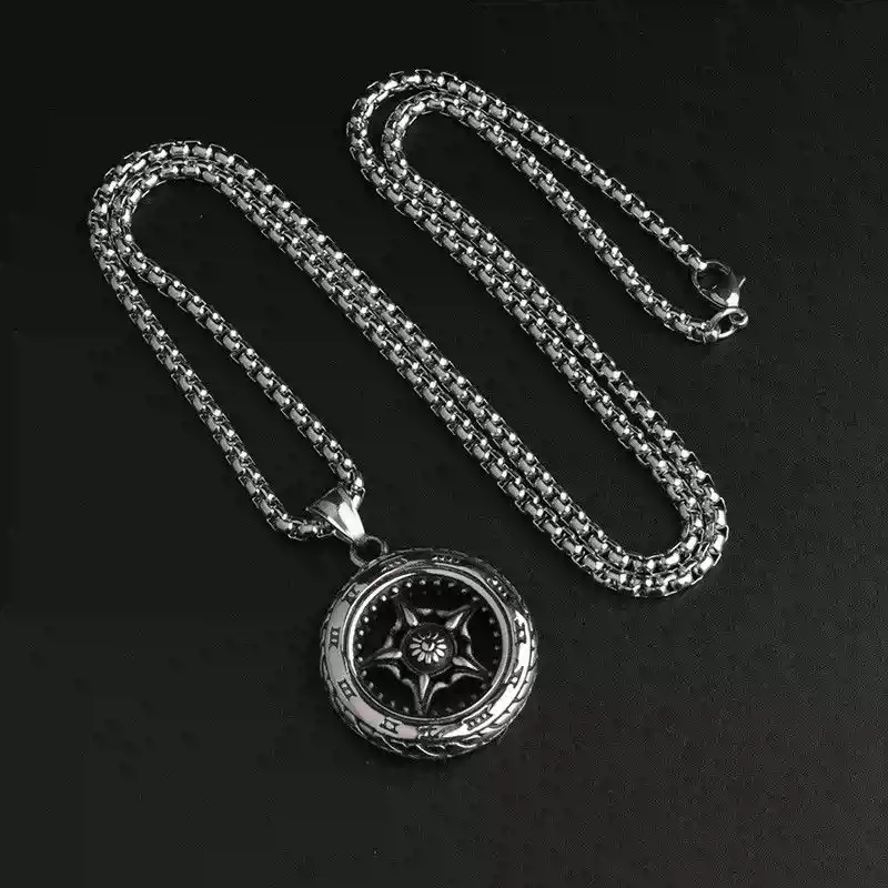 Stainless steel motorcycle tire and wheel rim pendant necklace laid out on a black background.