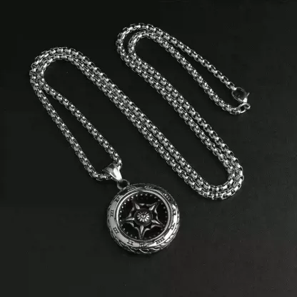 Stainless steel motorcycle tire and wheel rim pendant necklace laid out on a black background.