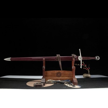 Medieval longsword with leather scabbard displayed on a wooden stand, side profile view.
