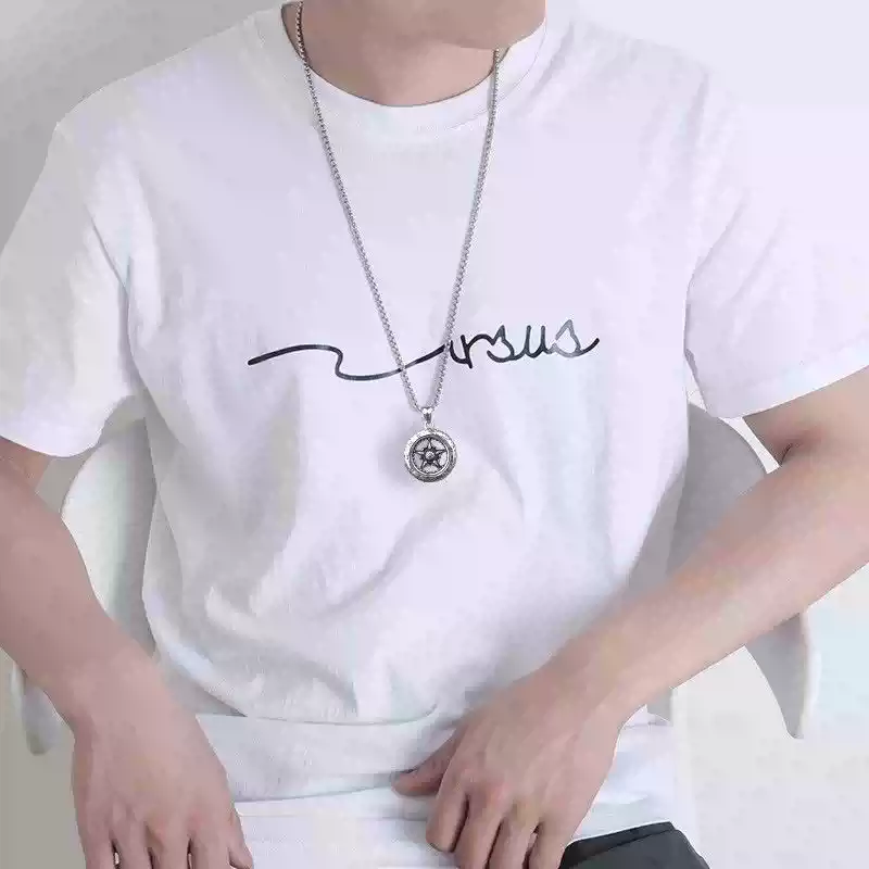 A man wearing a long silver motorcycle wheel tire necklace over a white t-shirt.