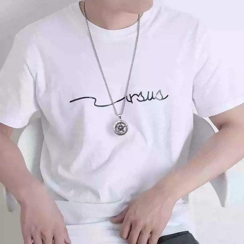 A man wearing a long silver motorcycle wheel tire necklace over a white t-shirt.