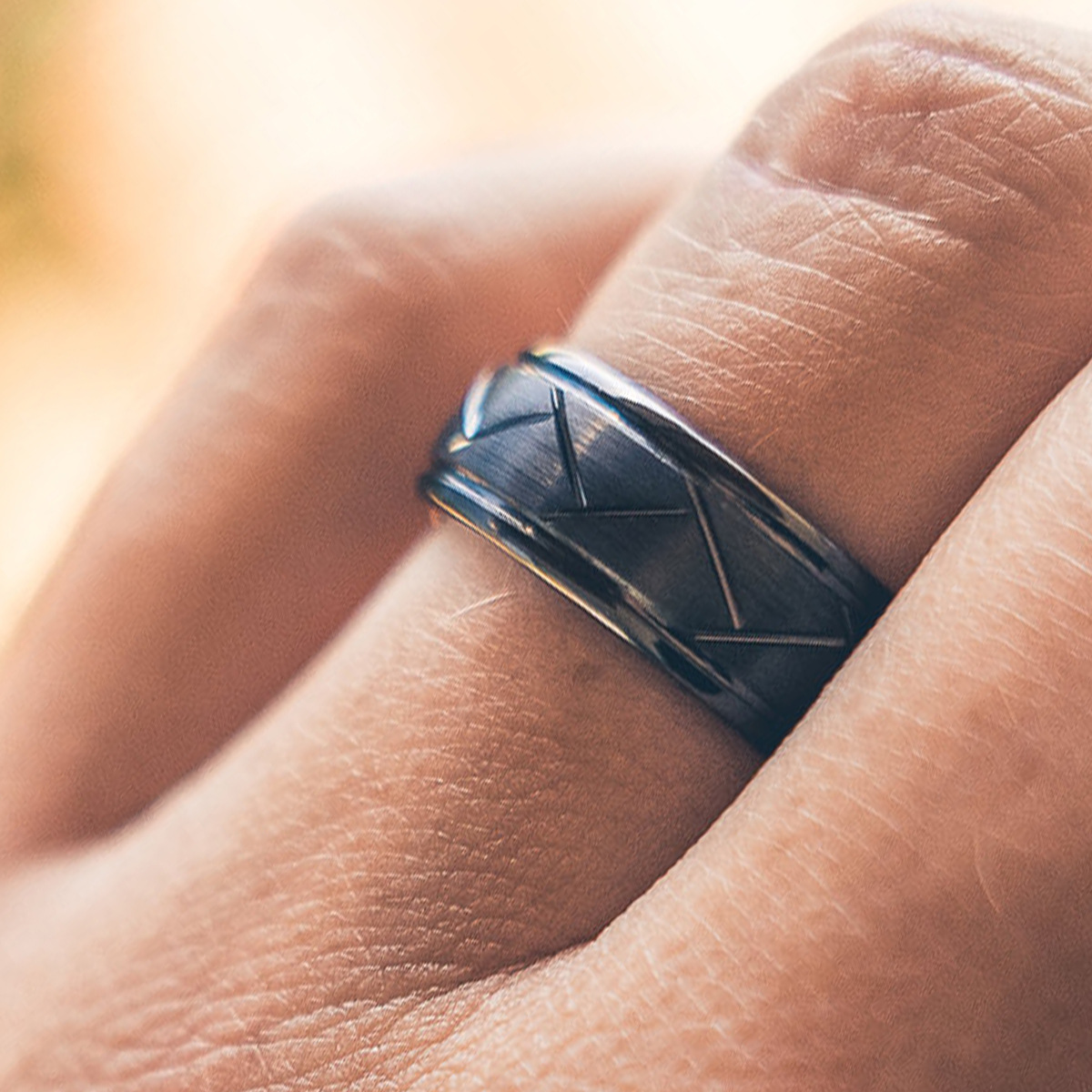 Close-up of a person wearing the black motorcycle tire tread ring on their finger, showing its real-life scale and width.
