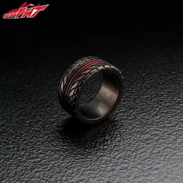 A close-up side-angle view of a black motorcycle tire tread ring with a red stripe, set against a dark textured background.