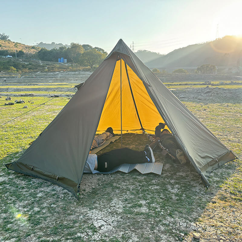 Interior view of the spacious pyramid tent showing camping mats and room for multiple campers.