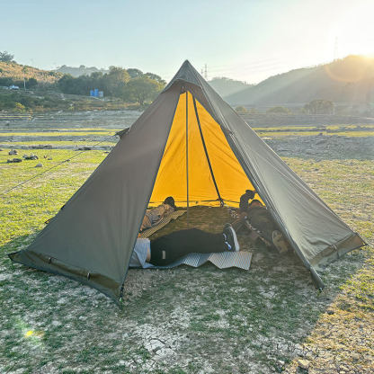 Interior view of the spacious pyramid tent showing camping mats and room for multiple campers.