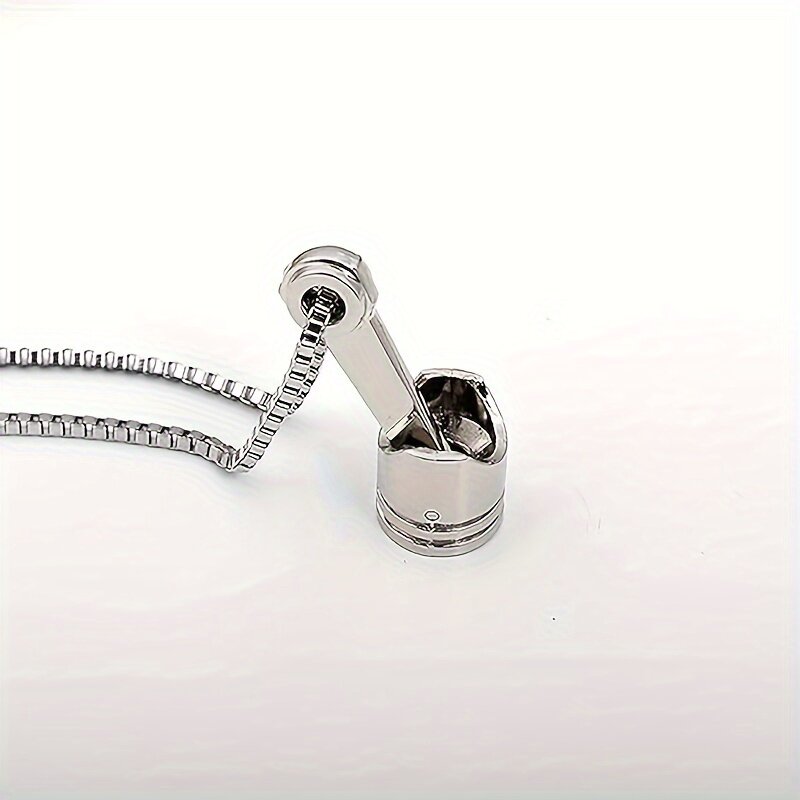 A silver stainless steel motorcycle piston pendant necklace showcasing a punk style design on a white background.
