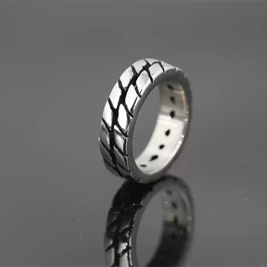 Alternative profile view of the Safe Haven Armor motorcycle tire ring, highlighting the metallic finish and unique tire track texture.
