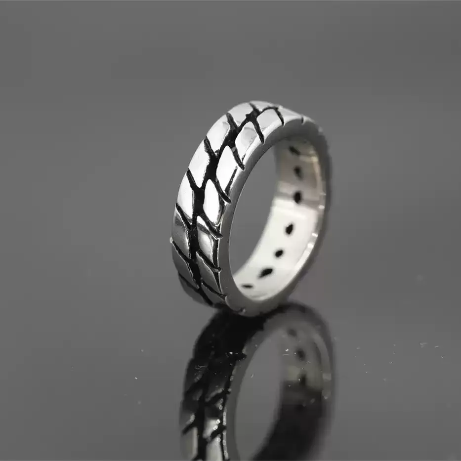 Alternative profile view of the Safe Haven Armor motorcycle tire ring, highlighting the metallic finish and unique tire track texture.