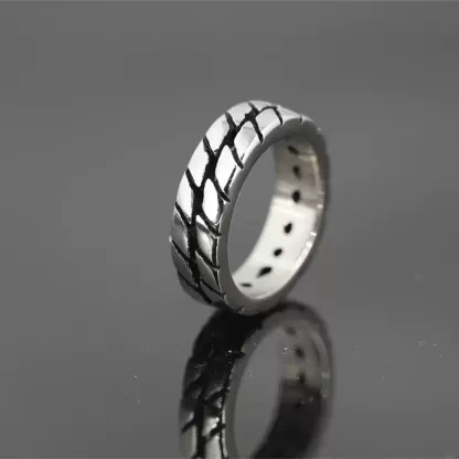 Alternative profile view of the Safe Haven Armor motorcycle tire ring, highlighting the metallic finish and unique tire track texture.