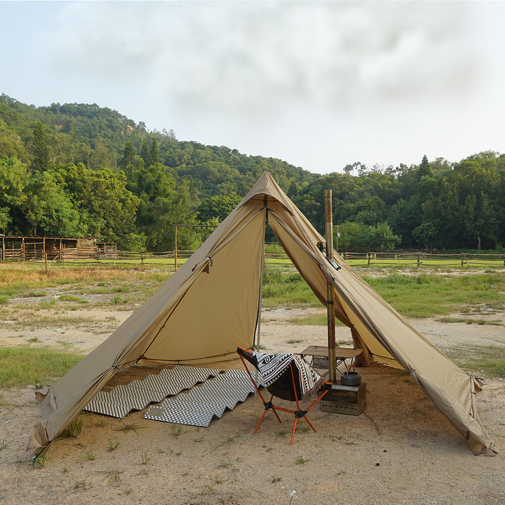 An open tan pyramid hot tent showing the full interior camping setup, including a portable wood stove, stove pipe, and a camping chair.