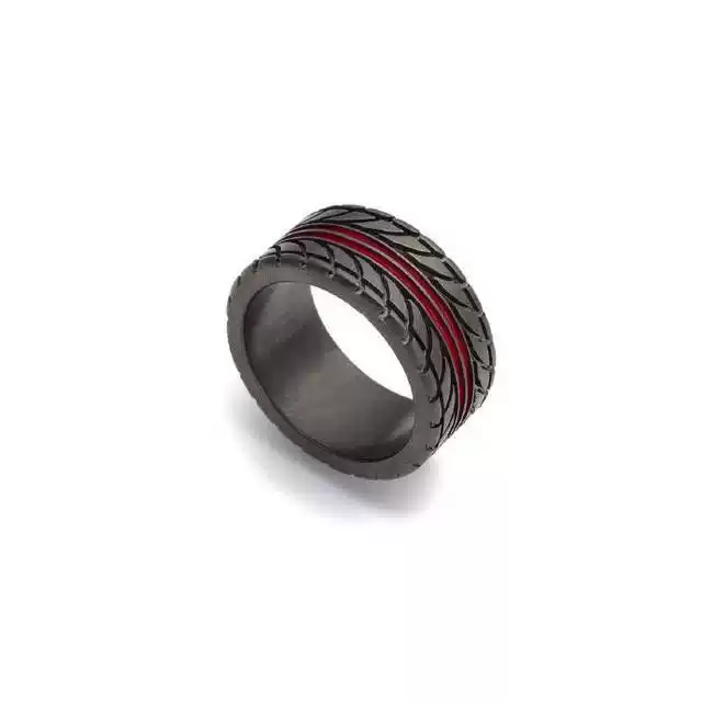 An angled close-up view on white background of a black motorcycle tire tread pattern wedding band with a thin red accent line.