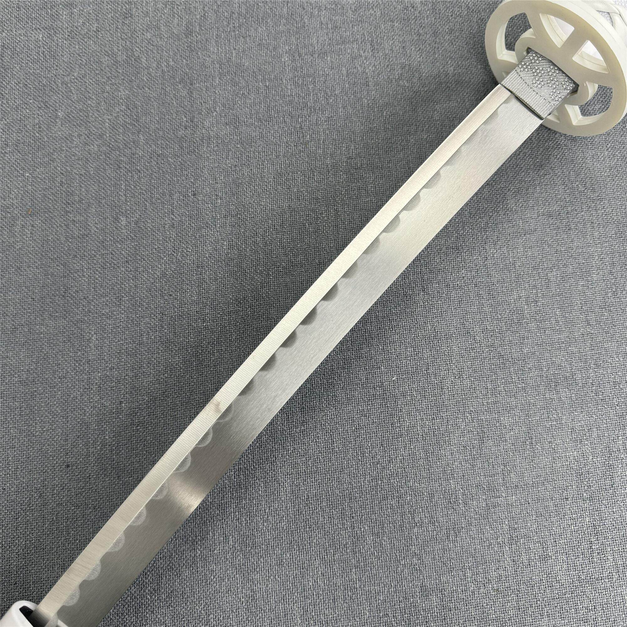 Close-up of the intricate white circular tsuba guard and textured habaki on the Kuchiki Unleashed katana.